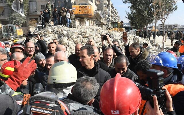 Le président syrien Bashar al-Assad salue la foule alors qu'il visite les quartiers touchés par un tremblement de terre dans la ville d'Alep, au nord du pays, le 10 février 2023. (Crédit : AFP) Le président syrien Bashar al-Assad salue la foule alors qu'il visite les quartiers touchés par un tremblement de terre dans la ville d'Alep, au nord du pays, le 10 février 2023. (Crédit : AFP)