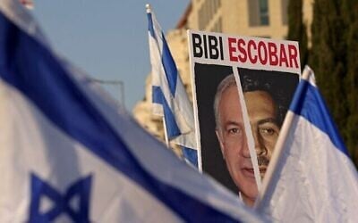 Illustration : Affiche comparant le Premier ministre Benjamin Netanyahu au baron de la drogue colombien, Pablo Escobar, lors d’une manifestation contre la réforme judiciaire, à Jérusalem, le 20 février 2023. (Crédit : Ronaldo Schemidt/AFP)