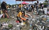 Sur cette photo d'archive prise le 17 septembre 2022, un volontaire de Trash Hero Bangkok trie les déchets plastiques d'une zone de mangrove dans la province côtière de Samut Prakan lors de la Journée mondiale du nettoyage. Le gouvernement thaïlandais s'apprête à éliminer progressivement l'importation de déchets plastiques dans le royaume d'ici 2025 après que le cabinet a approuvé la mesure. (Crédit : Lillian SUWANRUMPHA / AFP)