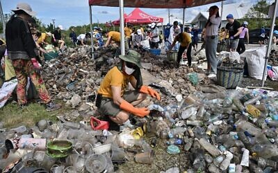 Sur cette photo d'archive prise le 17 septembre 2022, un volontaire de Trash Hero Bangkok trie les déchets plastiques d'une zone de mangrove dans la province côtière de Samut Prakan lors de la Journée mondiale du nettoyage. Le gouvernement thaïlandais s'apprête à éliminer progressivement l'importation de déchets plastiques dans le royaume d'ici 2025 après que le cabinet a approuvé la mesure. (Crédit : Lillian SUWANRUMPHA / AFP)