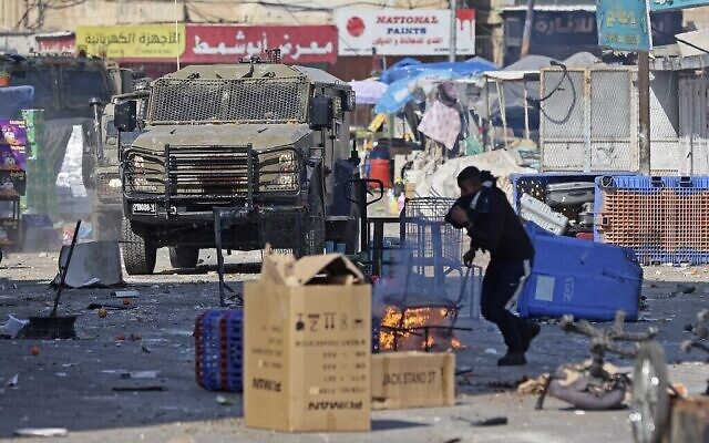 Des Palestiniens se heurtent aux forces israéliennes dans le cadre d'un raid israélien à Naplouse, en Cisjordanie, le 22 février 2023. (Crédit : Zain Jaafar / AFP) Des Palestiniens se heurtent aux forces israéliennes dans le cadre d'un raid israélien à Naplouse, en Cisjordanie, le 22 février 2023. (Crédit : Zain Jaafar / AFP)