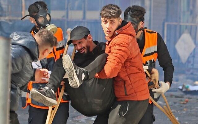 Des Palestiniens transportant un homme blessé lors d'une opération israélienne dans la ville de Naplouse, en Cisjordanie, le 22 février 2023. (Crédit : Zain Jaafar/AFP) Des Palestiniens transportant un homme blessé lors d'une opération israélienne dans la ville de Naplouse, en Cisjordanie, le 22 février 2023. (Crédit : Zain Jaafar/AFP)