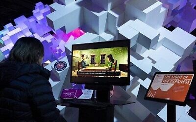 Jacquelyne Vargas joue au jeu vidéo "The Light in the Darkness", qui raconte l'histoire d'une famille de Juifs polonais en France pendant la Shoah, lors de l'Indie Game Revolution au Musée de la culture populaire (MoPOP) à Seattle, Washington, le 23 février 2023. (Crédit : Jason Redmond/AFP)