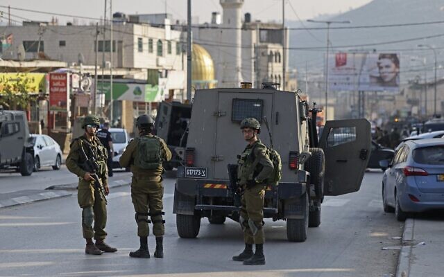 Les forces de sécurité israéliennes déployées après la mort de deux Israéliens dans une fusillade, à Huwara, le 26 février 2023. (Crédit : Ahmad Gharabli/AFP) Les forces de sécurité israéliennes déployées après la mort de deux Israéliens dans une fusillade, à Huwara, le 26 février 2023. (Crédit : Ahmad Gharabli/AFP)
