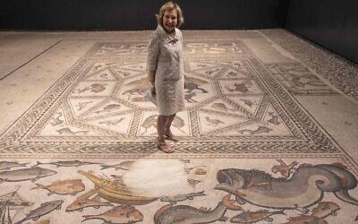 La philanthrope Shelby White au centre de la mosaïque de Lod, vieille de 1700 ans, avant l'inauguration d'un nouveau centre d'accueil des visiteurs qu'elle a contribué à financer pour présenter cette pièce précieuse dans la ville israélienne de Lod, le 27 juin 2022. (Crédit : Menahem Kahana/AFP via Getty Images)