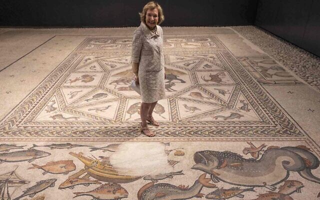 La philanthrope Shelby White au centre de la mosaïque de Lod, vieille de 1700 ans, avant l'inauguration d'un nouveau centre d'accueil des visiteurs qu'elle a contribué à financer pour présenter cette pièce précieuse dans la ville israélienne de Lod, le 27 juin 2022. (Crédit : Menahem Kahana/AFP via Getty Images) La philanthrope Shelby White au centre de la mosaïque de Lod, vieille de 1700 ans, avant l'inauguration d'un nouveau centre d'accueil des visiteurs qu'elle a contribué à financer pour présenter cette pièce précieuse dans la ville israélienne de Lod, le 27 juin 2022. (Crédit : Menahem Kahana/AFP via Getty Images)