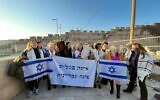 Des rabbins réformés et des partisans de Women of the Wall marchent vers le mur Occidental avec une pancarte protestant contre un projet de loi qui criminaliserait les femmes portant un châle de prière sur le lieu saint, le 22 février 2023. (Crédit : Conférence centrale des rabbins américains)