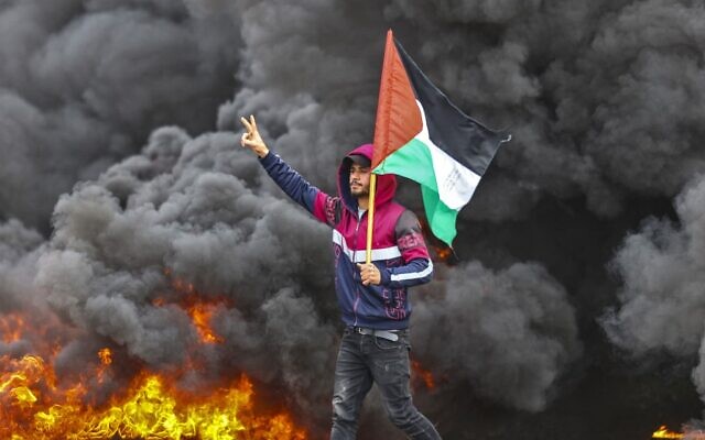 De jeunes Palestiniens protestent près de la frontière entre Israël et Gaza, à l'est du camp de réfugiés de Jabalia, le 23 février 2023. (Crédit : MAHMUD HAMS/AFP)