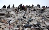 Des habitants et des sauveteurs recherchent des victimes et des survivants dans les décombres de bâtiments effondrés à la suite d'un tremblement de terre dans le village de Besnaya, dans la province d'Idlib, au nord-ouest de la Syrie, tenue par les rebelles, à la frontière avec la Turquie, le 6 février 2022. (Crédit : OMAR HAJ KADOUR / AFP)