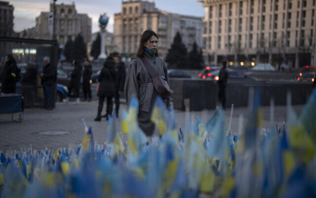 Illustration : Une femme s’arrête un instant pour regarder les drapeaux ukrainiens placés en mémoire de ceux qui ont été tués pendant la guerre, près de la place Maïdan dans le centre de Kiev, en Ukraine, le 20 janvier 2023. (Crédit : Daniel Cole/AP)