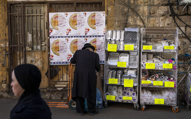 Un juif ultra-orthodoxe achetant de la vaisselle en plastique jetable dans le quartier de Mea Shearim, à Jérusalem, le 20 janvier 2023. (Crédit : Oded Balilty/AP) Un juif ultra-orthodoxe achetant de la vaisselle en plastique jetable dans le quartier de Mea Shearim, à Jérusalem, le 20 janvier 2023. (Crédit : Oded Balilty/AP)
