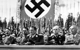 Assis de gauche à droite : Hitler, Rudolf Hess, chef adjoint du parti nazi, Hermann Goering, président du Reichstag, Joachim Von Ribbentrop, ministre allemand des Affaires étrangères, Wilhelm Frick, ministre allemand de l'Intérieur. Le ministre allemand de la Propagande, le Dr. Joseph Goebbels, non visible, présentant le chancelier allemand Adolf Hitler, à gauche, au grand public du Palais des sports, à Berlin, le 26 septembre 1938. (Crédit : Photo AP)