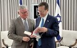 Le président du groupe britannique Labour Friends of Israel, le député vétéran Steve McCabe, à gauche, donne un livre signé par le chef de sa formation, Keir Starmer, au président Isaac Herzog, le 6 février 2023. (Crédit : Labour Friends of Israel)
