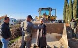La députée Otzma Yehudit, Limor Son Har Melech, se tenant devant un bulldozer sur un terrain près de l'implantation de Shiloh en Cisjordanie afin d'arrêter le déracinement des arbres par l'Administration civile du ministère de la Défense, le 15 février 2023. (Crédit : Bureau de Limor Son Har Melech)