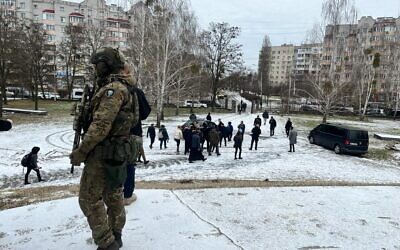 Un soldat ukrainien surveillant la visite du ministre des Affaires étrangères, Eli Cohen, à Boutcha, en Ukraine, le 16 février 2023. (Crédit : Lazar Berman/The Times of Israel)