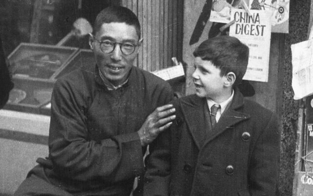  Un vendeur de journaux de Shanghai avec un jeune réfugié juif pendant la Seconde Guerre mondiale. (Crédit : Above the Drowning Sea/ Time & Rhythm Cinema)