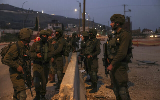Des soldats de Tsahal patrouillant sur la route principale de Huwara, en Cisjordanie, le 27 février 2023. (Crédit : Ronaldo Schemidt/AFP) Des soldats de Tsahal patrouillant sur la route principale de Huwara, en Cisjordanie, le 27 février 2023. (Crédit : Ronaldo Schemidt/AFP)