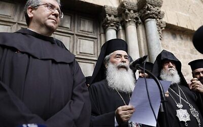 Le patriarche grec-orthodoxe de Jérusalem Théophile III lit un communiqué à la presse aux côtés du gardien de la terre sainte, le frère Francesco Patton et de l'évêque arménien Siwan,à gauche, devant les portes closes de l'église du saint-sépulcre, dans la Vieille Ville de Jérusalem, le 25 février 2018 (Crédit : AFP/ GALI TIBBON) Le patriarche grec-orthodoxe de Jérusalem Théophile III lit un communiqué à la presse aux côtés du gardien de la terre sainte, le frère Francesco Patton et de l'évêque arménien Siwan,à gauche, devant les portes closes de l'église du saint-sépulcre, dans la Vieille Ville de Jérusalem, le 25 février 2018 (Crédit : AFP/ GALI TIBBON)