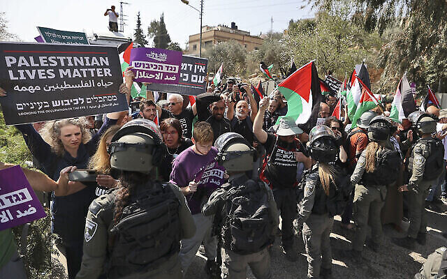 Les forces de l'ordre israéliennes bloquent des militants pacifistes palestiniens et israéliens qui manifestent à l’entrée de Huwara en Cisjordanie, le 3 mars 2023. (Crédit : Jaafar Ashtiyeh/AFP)
