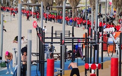 Des centaines de femmes vêtues de rouge marquant la Journée internationale de la femme et manifestant contre la réforme du système judiciaire prévue par le gouvernement, sur la plage de Tel Aviv, le 8 mars 2023. (Crédit : Tomer Neuberg/Flash90)
