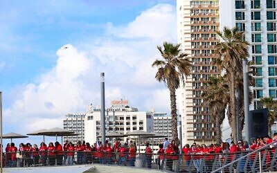 Des centaines de femmes vêtues de rouge marquant la Journée internationale de la femme et manifestant contre la réforme du système judiciaire prévue par le gouvernement, sur la plage de Tel Aviv, le 8 mars 2023. (Crédit : Tomer Neuberg/Flash90)