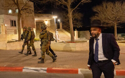 Des soldats israéliens patrouillent dans l'implantation de Beitar Illit, en Cisjordanie, suite à l'infiltration de l'homme qui a placé une bombe de fortune, le 10 mars 2023. (Crédit : Yonatan Sindel/Flash90)