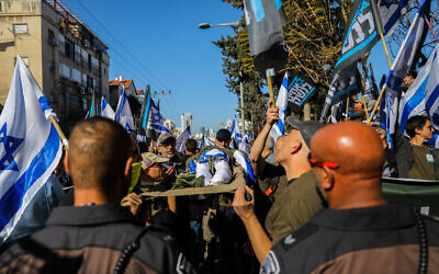 Des soldats de réserve israéliens et des activistes protestant contre la réforme du système judiciaire prévue par le gouvernement, à Bnei Brak, le 16 mars 2023. (Crédit : Flash90)