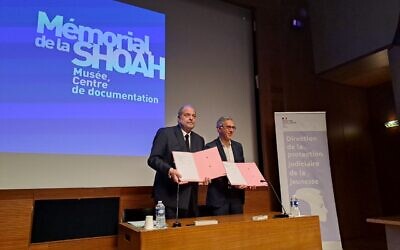 Signature d’une convention entre la Direction de la protection judiciaire de la jeunesse et le mémorial de la Shoah de Paris, avec le ministre de la Justice français Eric Dupond-Moretti, et Jacques Fredj, directeur du mémorial de la Shoah, le 28 février 2023, au mémorial de la Shoah de Paris. (Crédit : Porte-parole du ministère de la Justice / Twitter)