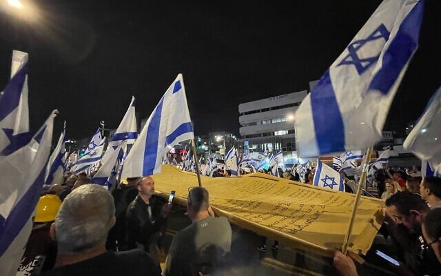 Des manifestants anti-gouvernement portant une Déclaration d'Indépendance géante alors qu'ils défilent à Bnei Brak le 23 mars 2023. (Crédit : Carrie Keller-Lynn/Times of Israel) Des manifestants anti-gouvernement portant une Déclaration d'Indépendance géante alors qu'ils défilent à Bnei Brak le 23 mars 2023. (Crédit : Carrie Keller-Lynn/Times of Israel)