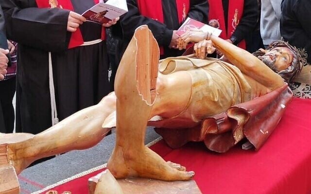 Les responsables catholiques autour d'une statue de Jésus vandalisée, le 24 mars 2023. (Crédit :Filippo De Grazia)