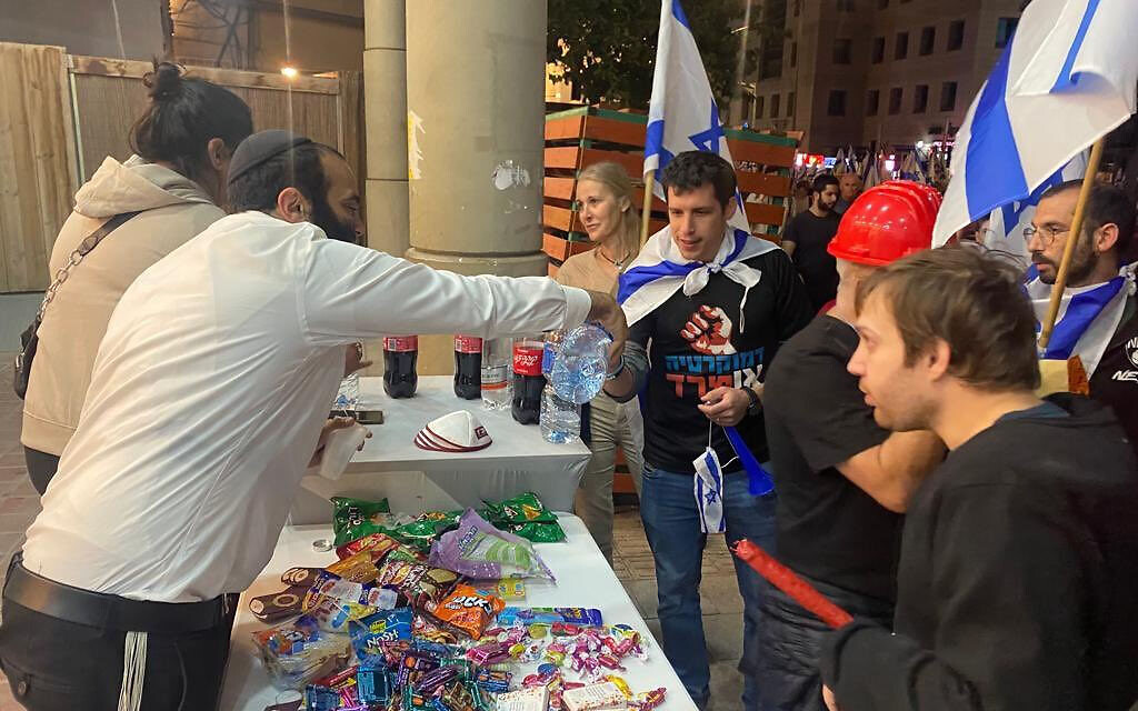 Les résidents offrant des collations et de l'eau aux manifestants venus protester contre la refonte judiciaire, à Bnei Brak, le 23 mars 2023. (Crédit : Haim Uzan) Les résidents offrant des collations et de l'eau aux manifestants venus protester contre la refonte judiciaire, à Bnei Brak, le 23 mars 2023. (Crédit : Haim Uzan)