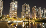 Des immeubles éclairés, à Petah Tikva, en août 2021. (Crédit : Itay Tamir via iStock par Getty Images)