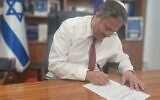 Le ministre de la Sécurité nationale, Itamar Ben Gvir signe une ordonnance concernant la fermeture des bureaux, à Jérusalem, de la station de radio Voix de Palestine, le 20 mars 2023. (Crédit :  National Security Ministry)