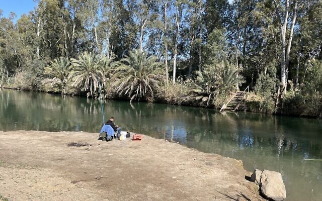 Un homme pêche dans le Jourdain, en aval du barrage d’Alumot, le 21 février 2023. (Crédit : Sue Surkes/Times of Israel)