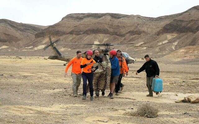 Les services de sécurité secourent une femme qui a été emportée par une crue soudaine dans le désert du Neguev, le 11 avril 2023. (Crédit : Police) Les services de sécurité secourent une femme qui a été emportée par une crue soudaine dans le désert du Neguev, le 11 avril 2023. (Crédit : Police)