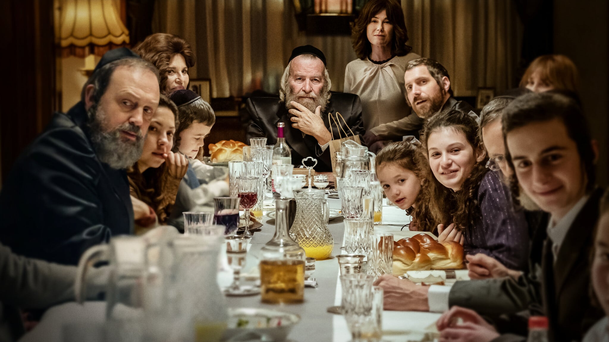 Dudu Fisher (au centre) dirige le dîner de Shabbat dans une scène de la série Netflix 'Rough Diamonds'. (Crédit : Netflix)