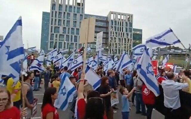 Des manifestants contre les projets de réforme du système judiciaire du gouvernement manifestent où le Premier ministre Benjamin Netanyahu devait visiter l'usine Steakholder, à Rehovot, le 19 avril 2023. (Crédit : Capture d'écran de la vidéo Twitter ; utilisée conformément à l'article 27a de la loi sur les droits d'auteur) Des manifestants contre les projets de réforme du système judiciaire du gouvernement manifestent où le Premier ministre Benjamin Netanyahu devait visiter l'usine Steakholder, à Rehovot, le 19 avril 2023. (Crédit : Capture d'écran de la vidéo Twitter ; utilisée conformément à l'article 27a de la loi sur les droits d'auteur)