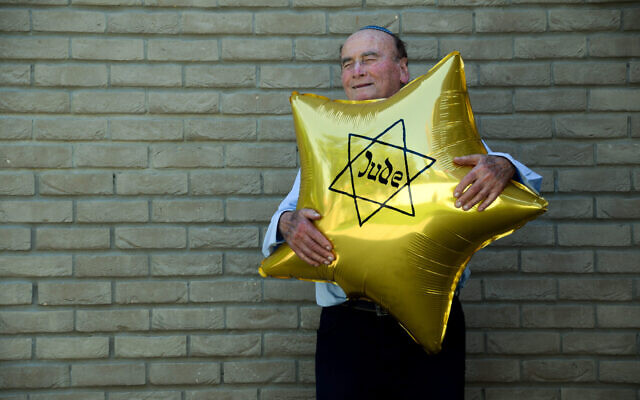 Dugo Leitner, un survivant d'Auschwitz-Birkenau, tenant un ballon en forme d'étoile juive que les nazis obligeaient les Juifs à porter. (Crédit : Erez Kaganovitz via JTA)