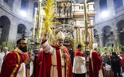 Pierbattista Pizzaballa, patriarche latin de Jérusalem, tenant une palme lors d'une procession à l'Édicule, traditionnellement considéré comme le lieu de sépulture de Jésus-Christ, lors de la messe catholique du dimanche des Rameaux, à l'église du Saint-Sépulcre à Jérusalem, le 2 avril 2023. (Crédit : Menahem Kahana/AFP)