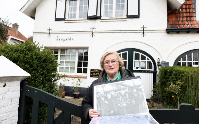 La guide touristique belge Brigitte Hochs montre une photo du scientifique Albert Einstein le 20 avril 2023 à De Haan/Le Coq, devant la villa "Savoyarde" où le célèbre scientifique allemand a vécu pendant six mois en 1933 après avoir quitté l'Allemagne. (Crédit : Kenzo TRIBOUILLARD / AFP) La guide touristique belge Brigitte Hochs montre une photo du scientifique Albert Einstein le 20 avril 2023 à De Haan/Le Coq, devant la villa "Savoyarde" où le célèbre scientifique allemand a vécu pendant six mois en 1933 après avoir quitté l'Allemagne. (Crédit : Kenzo TRIBOUILLARD / AFP)