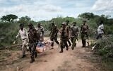 Des agents de sécurité transportent une jeune personne sauvée de la forêt à Shakahola, à l'extérieur de la ville côtière de Malindi, le 23 avril 2023. (Crédit : Yasuyoshi CHIBA / AFP)