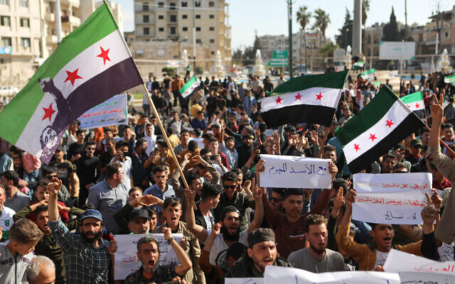 Des Syriens manifestant contre un dégel des liens entre plusieurs pays arabes et le régime du dictateur syrien Bashar el-Assad, dans la ville d'Idleb, tenue par les rebelles, le 23 avril 2023. (Crédit : Aaref Watad/AFP)