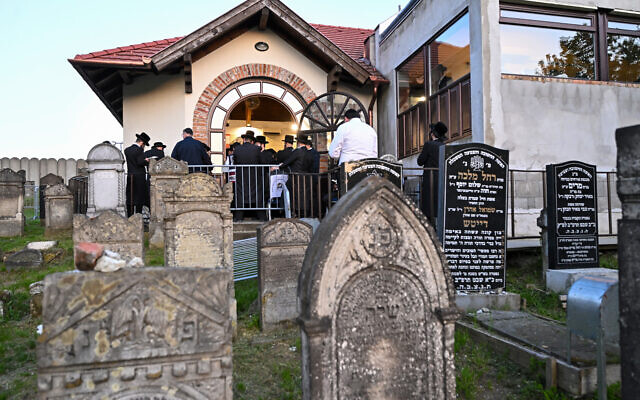Des Juifs hassidiques prient près de la tombe de feu le rabbin miracle Yeshaya Steiner, également connu sous le nom de Rebbe Shayale, dans le village de Bodrogkeresztur, en Hongrie, le 23 avril 2023, lors d'un pèlerinage de juifs hassidiques à l'occasion du 98e anniversaire de la mort du rabbin Steiner. (Crédit : ATTILA KISBENEDEK / AFP) Des Juifs hassidiques prient près de la tombe de feu le rabbin miracle Yeshaya Steiner, également connu sous le nom de Rebbe Shayale, dans le village de Bodrogkeresztur, en Hongrie, le 23 avril 2023, lors d'un pèlerinage de juifs hassidiques à l'occasion du 98e anniversaire de la mort du rabbin Steiner. (Crédit : ATTILA KISBENEDEK / AFP)