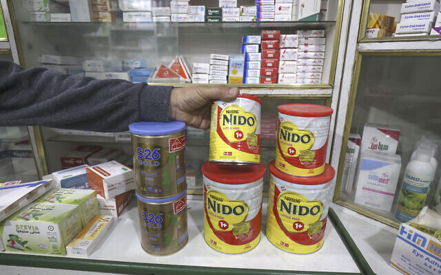 Une photo prise le 29 avril 2023 montre un pharmacien palestinien empilant des boîtes de lait maternisé en poudre dans sa pharmacie de la ville de Gaza. (Crédit : SAID KHATIB / AFP)