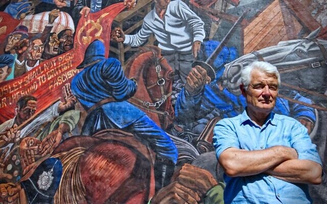 Le journaliste vétéran John Ware devant une fresque, sur Cable Street, dépeignant la fameuse "bataille" qui avait eu lieu en 1936 là-bas contre les fascistes d'Oswald Mosley qui défilaient à East End, à Londres, un quartier comptant une forte population juive. (Autorisation)