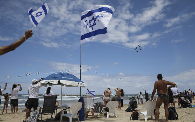 Des spectateurs regardent e de l'Air israélienne pour Yom HaAtsmaout à la plage de Tel Aviv, le 9 mai 2019.(Crédit : AP Photo/Oded Balilty) Des spectateurs regardent e de l'Air israélienne pour Yom HaAtsmaout à la plage de Tel Aviv, le 9 mai 2019.(Crédit : AP Photo/Oded Balilty)