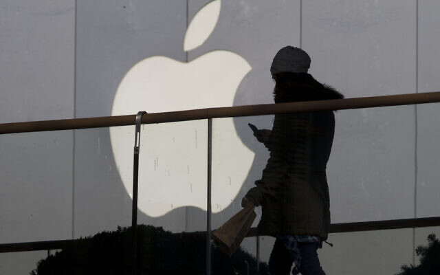Photo d'illustration : Une femme utilisant un téléphone passe devant le logo d'Apple devant un magasin de Pékin, le 23 décembre 2013. (Crédit : AP Photo/Ng Han Guan, File) Photo d'illustration : Une femme utilisant un téléphone passe devant le logo d'Apple devant un magasin de Pékin, le 23 décembre 2013. (Crédit : AP Photo/Ng Han Guan, File)