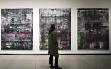 Des visiteurs devant la série « Birkenau » à la nouvelle exposition de l'artiste allemand Gerhard Richter à la Nouvelle Galerie nationale de Berlin, en Allemagne, le 31 mars 2023. (Crédit : AP Photo/Markus Schreiber)