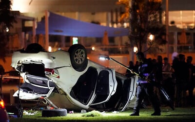 La police israélienne et les services d'urgence travaillent autour d'une voiture impliquée dans une attaque à la voiture bélier à Tel Aviv, Israël, le 7 avril 2023. (Crédit :  AP/Ariel Schalit)