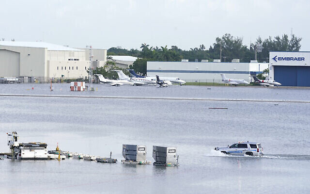 Un camion se déplace sur la piste inondée de l'aéroport international de Fort Lauderdale- Hollywood, le 13 avril 2023, à Fort Lauderdale, en Floride. (Crédit : AP Photo/Marta Lavandier) Un camion se déplace sur la piste inondée de l'aéroport international de Fort Lauderdale- Hollywood, le 13 avril 2023, à Fort Lauderdale, en Floride. (Crédit : AP Photo/Marta Lavandier)